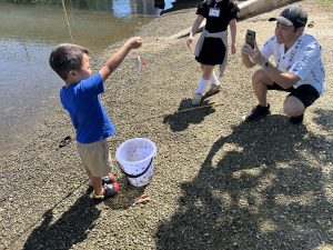 A keiki holds up his first caught fish