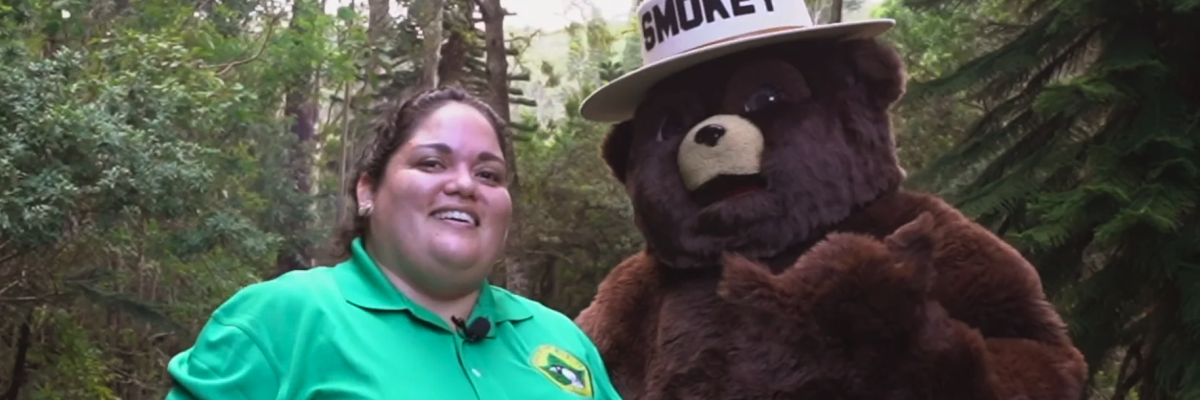 An image of a staff member standing by Smokey Bear