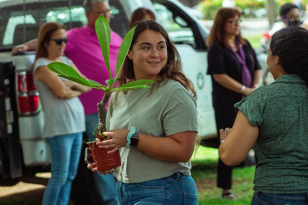 Woman holds plant at Arbor Day 2022