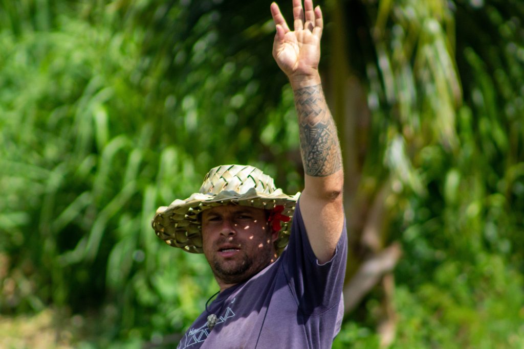 farmer in sun hat raises his arm