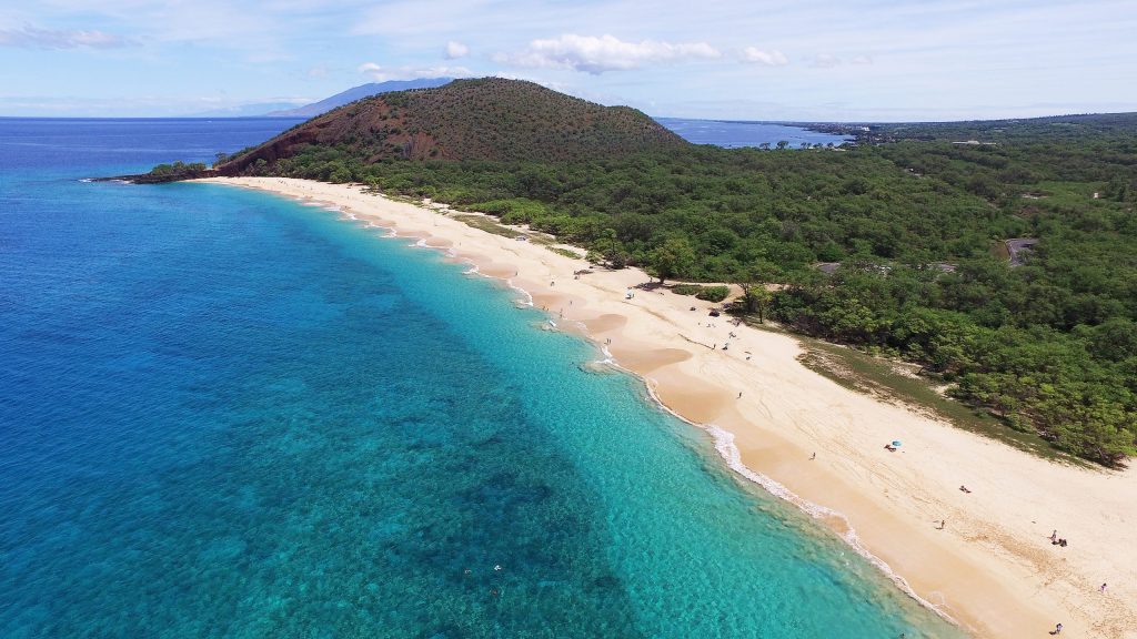 Aerial photo of Mākena State Park's long sandy beach on a sunny day, Maui, Hawaiʻi.
