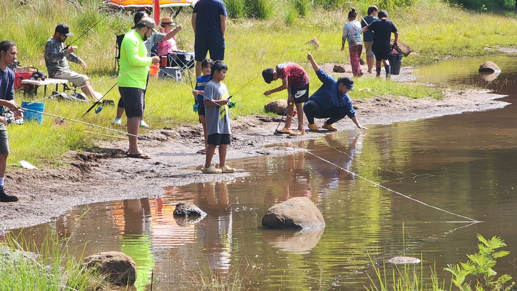 Photo of community members of various ages fishing for trout at the Pu'u Lua Reservoir on Kauai.
